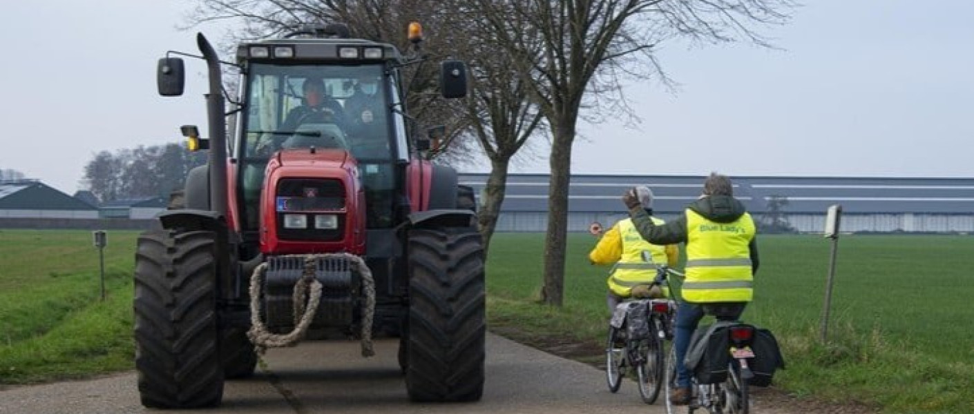 Een tractor neemt een groot deel van de weg in beslag. 
