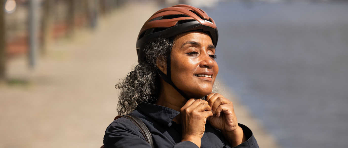 Vrouw die haar fietshelm op doet