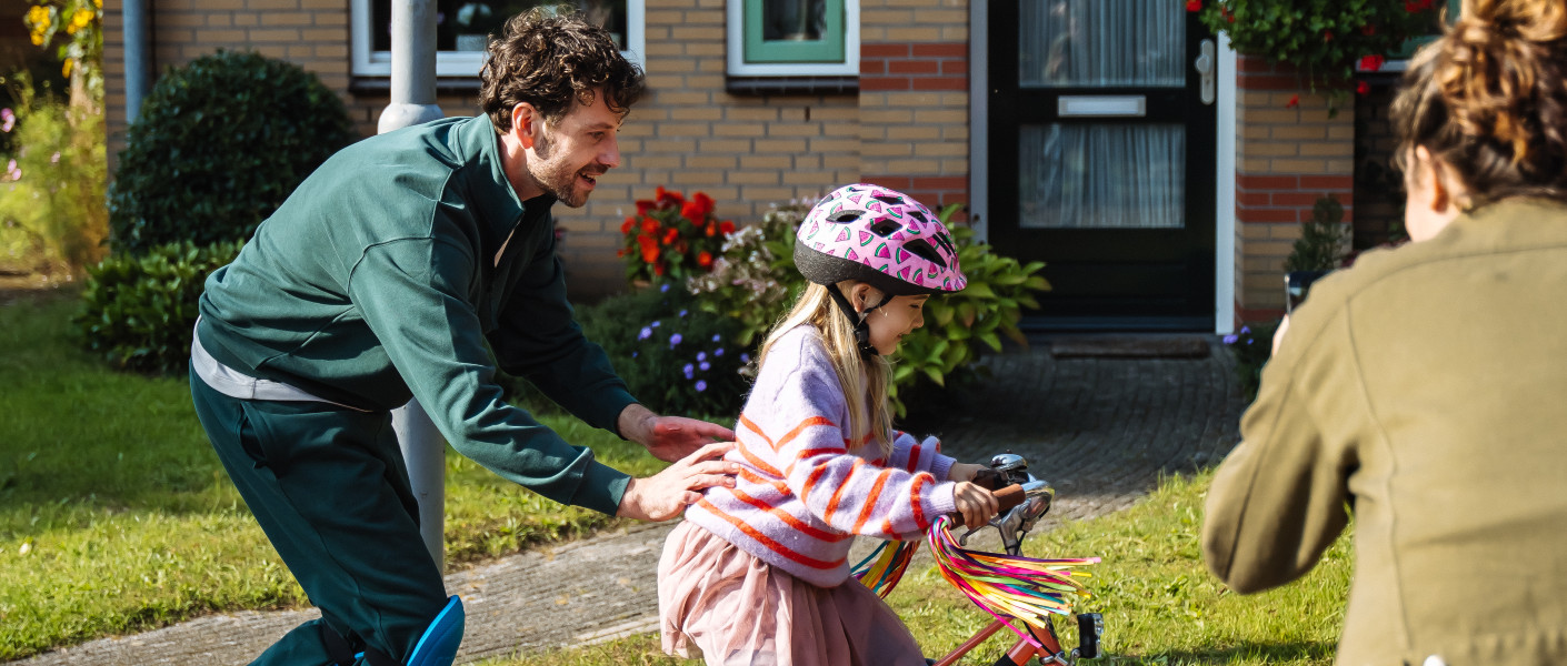 Papa leert zijn dochter fietsen