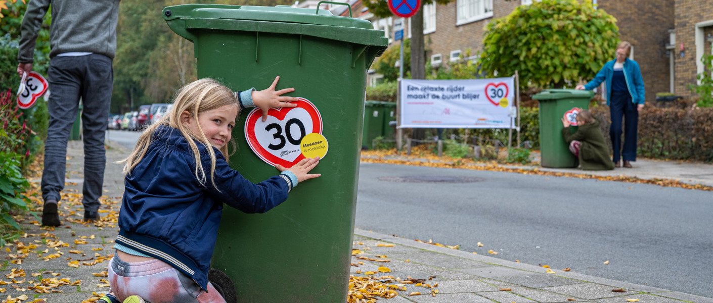 Meisje plakt 30 km/uur sticker op vuilnisbak