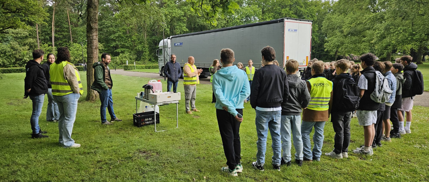 De leerlingen staan te luisteren naar de uitleg die gegeven wordt bij het Ploegpark.