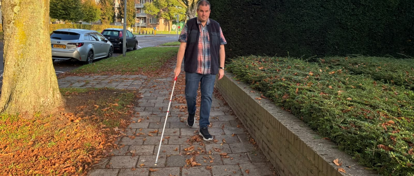 Foto van Ralf die over straat loopt met zijn witte stok