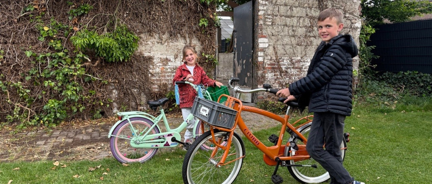 Twee kinderen staan naast hun fiets