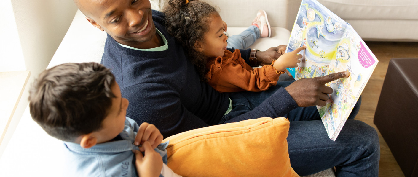 Vader en kinderen lezen Sproet en de Straathaaien