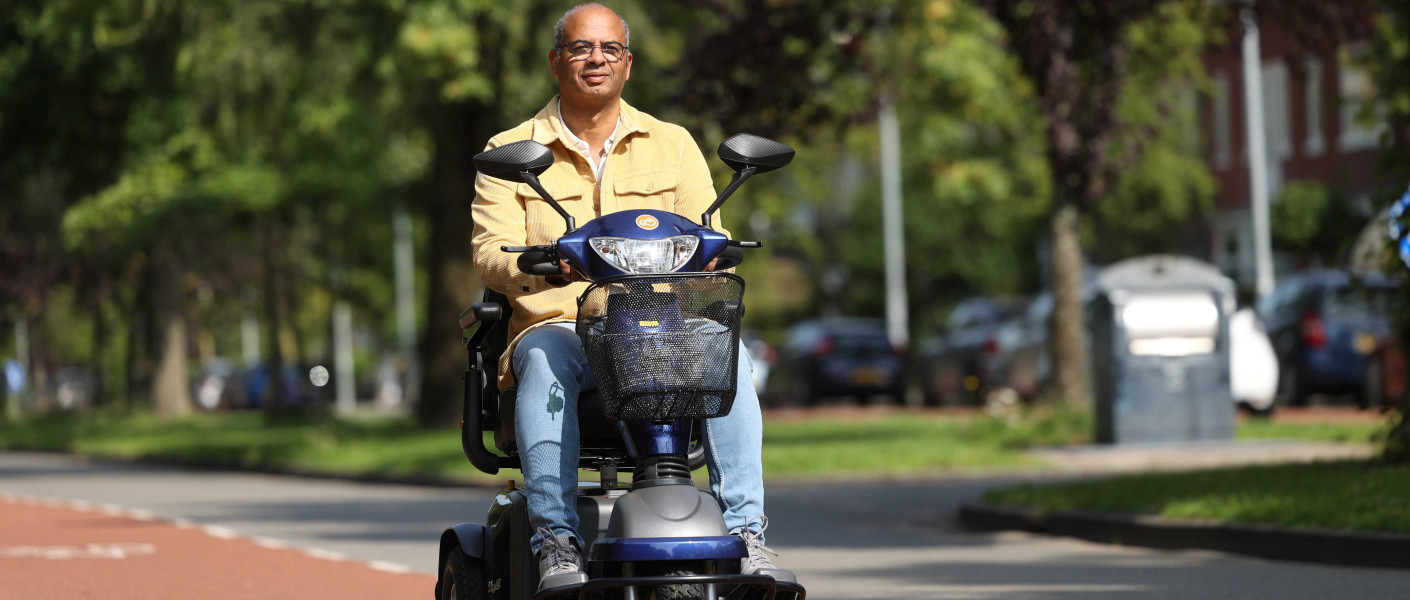 Meneer op de scootmobiel, rijdt op een fietspad