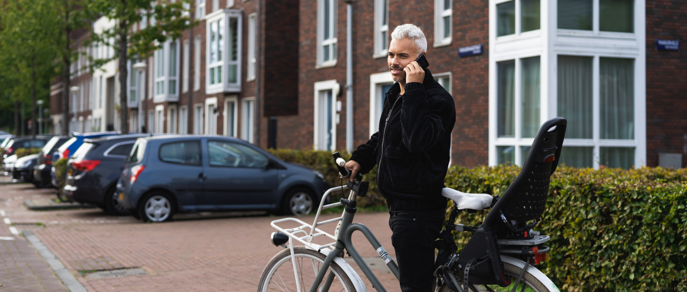 Man stapt af van zijn fiets om te bellen