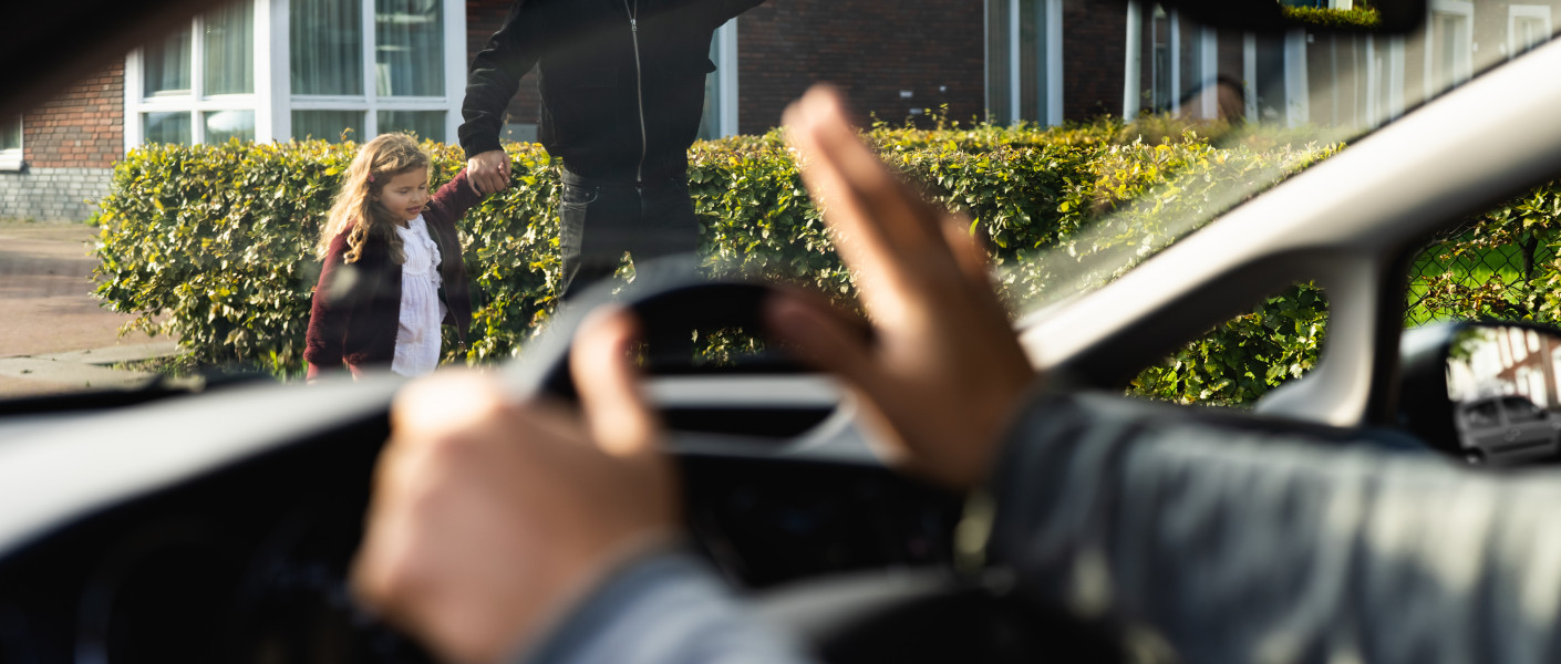 Automobilist zwaait naar voetganger