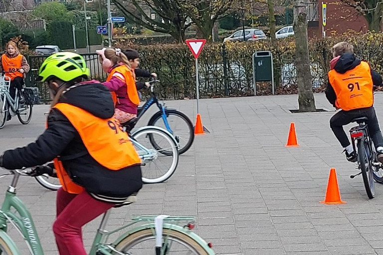 kinderen oefenen slalom op de fiets