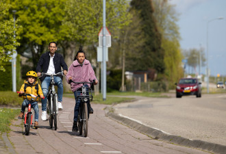 Vader en zoon en dochter oefenen met fietsen