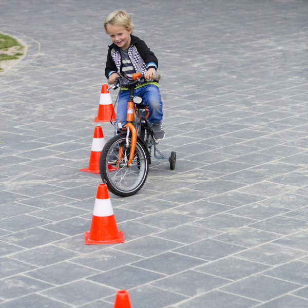 Jongen oefent verkeersvaardigheden op het schoolplein