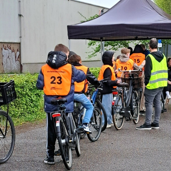 Nat geregende leerlingen op de tweede dag van het praktisch Verkeersexamen