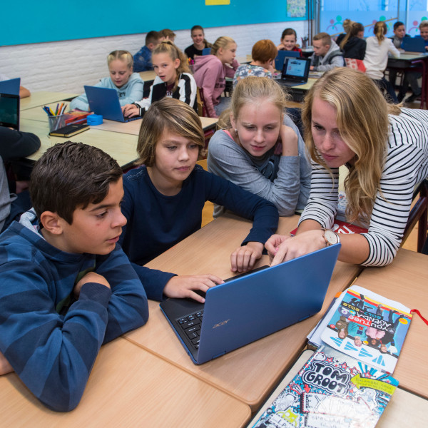 Groepje kinderen rond laptop in de klas