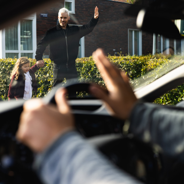 Automobilist zwaait naar voetganger