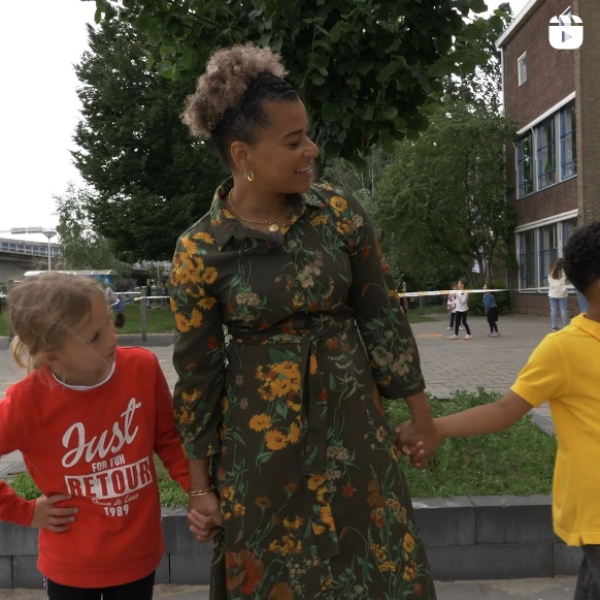 Juf met kinderen oefenen veilig over te steken op het schoolplein 