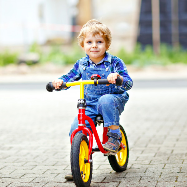 Jongen op loopfiets